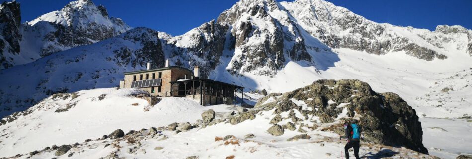 hiker is going to shelter in snowed mountains