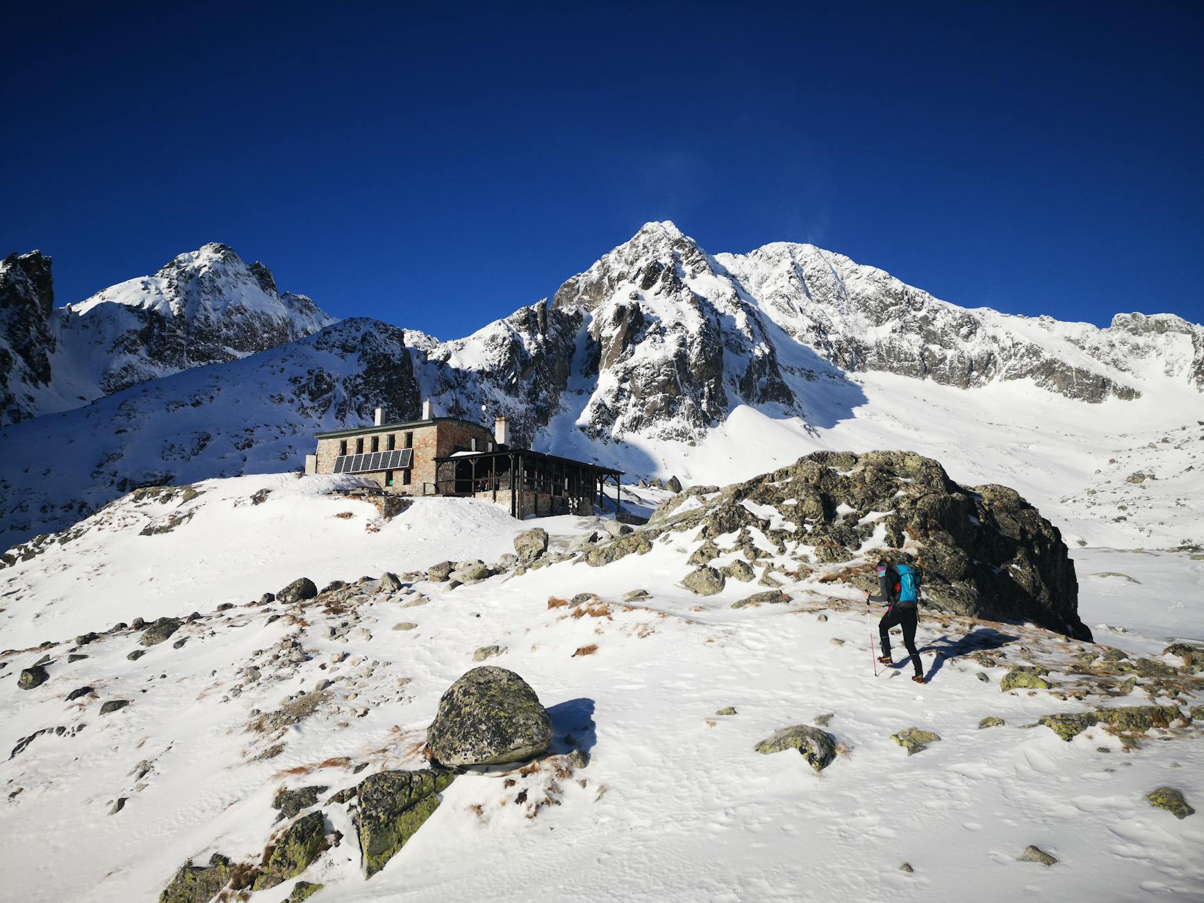hiker is going to shelter in snowed mountains