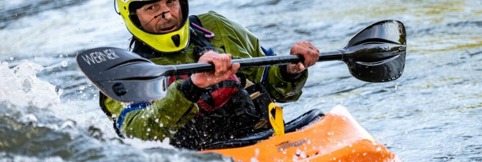 man riding orange kayak boat