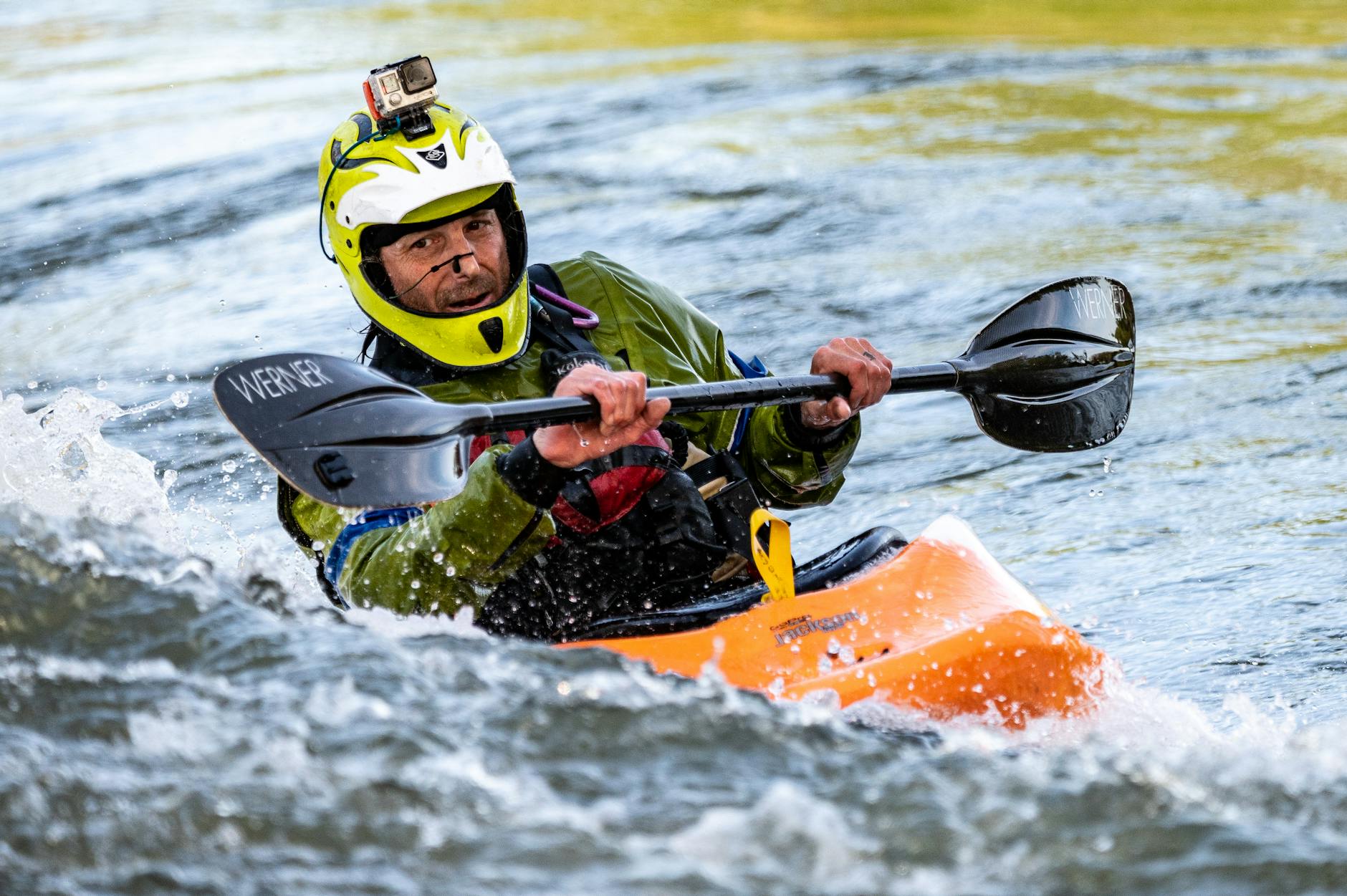 man riding orange kayak boat