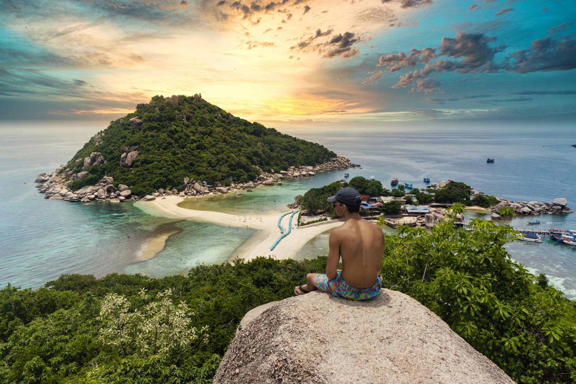 shirtless man sitting on a rock