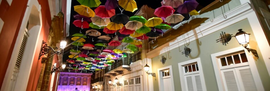 assorted coloured umbrellas hanging near buildings