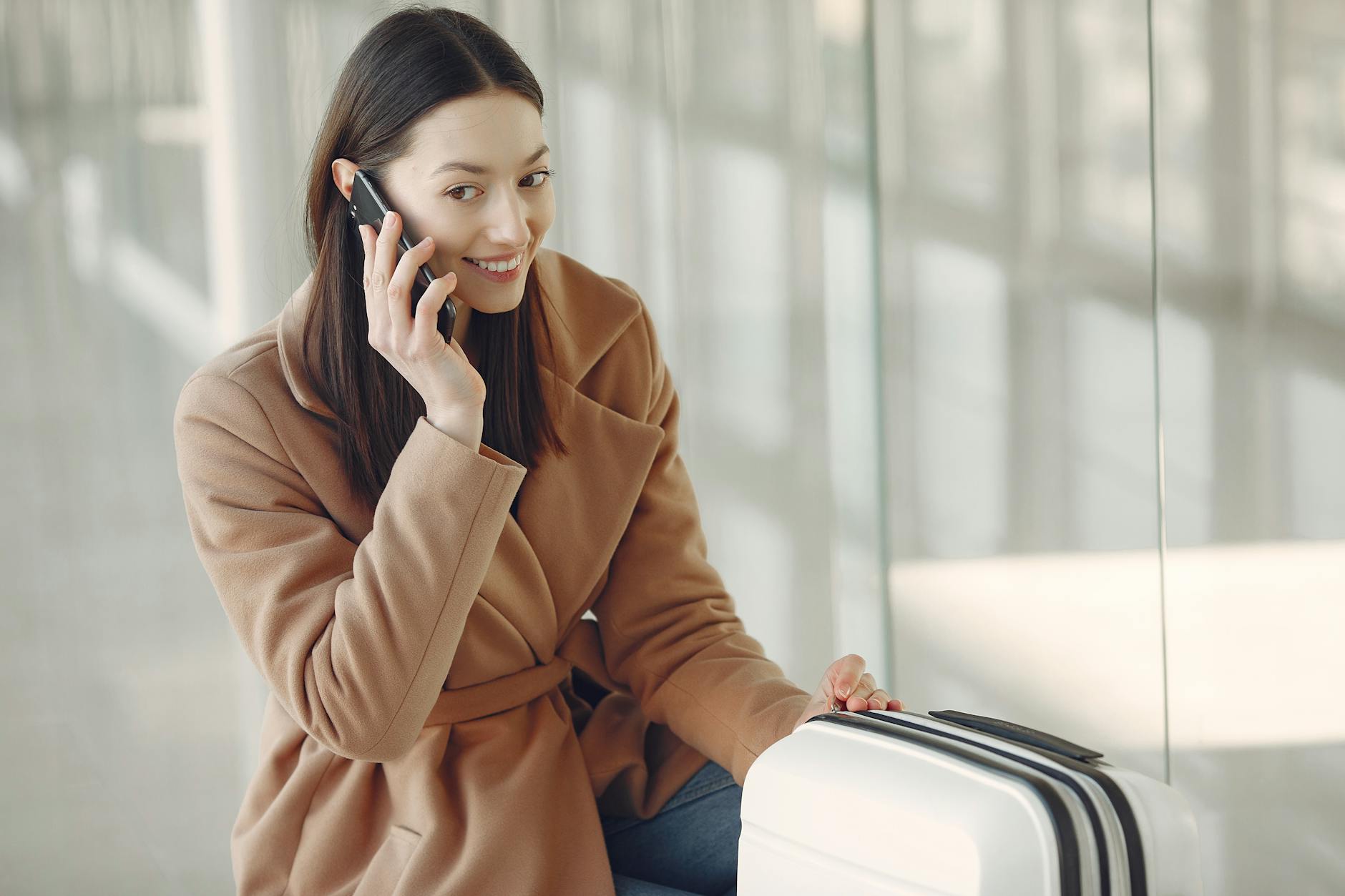 charming woman talking on smartphone in airport
