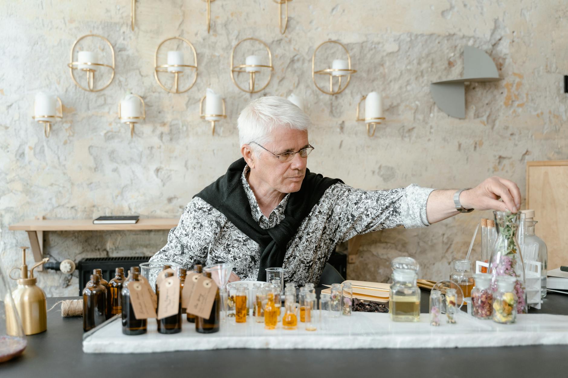 man sitting at table with assorted bottles