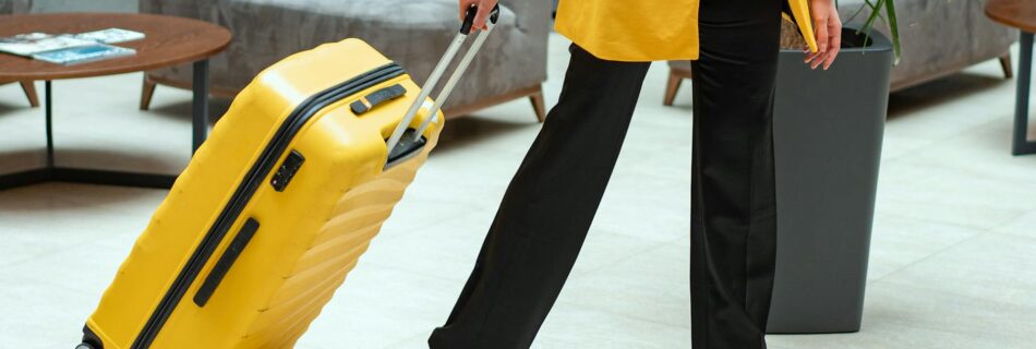 person in yellow coat pulling a suitcase