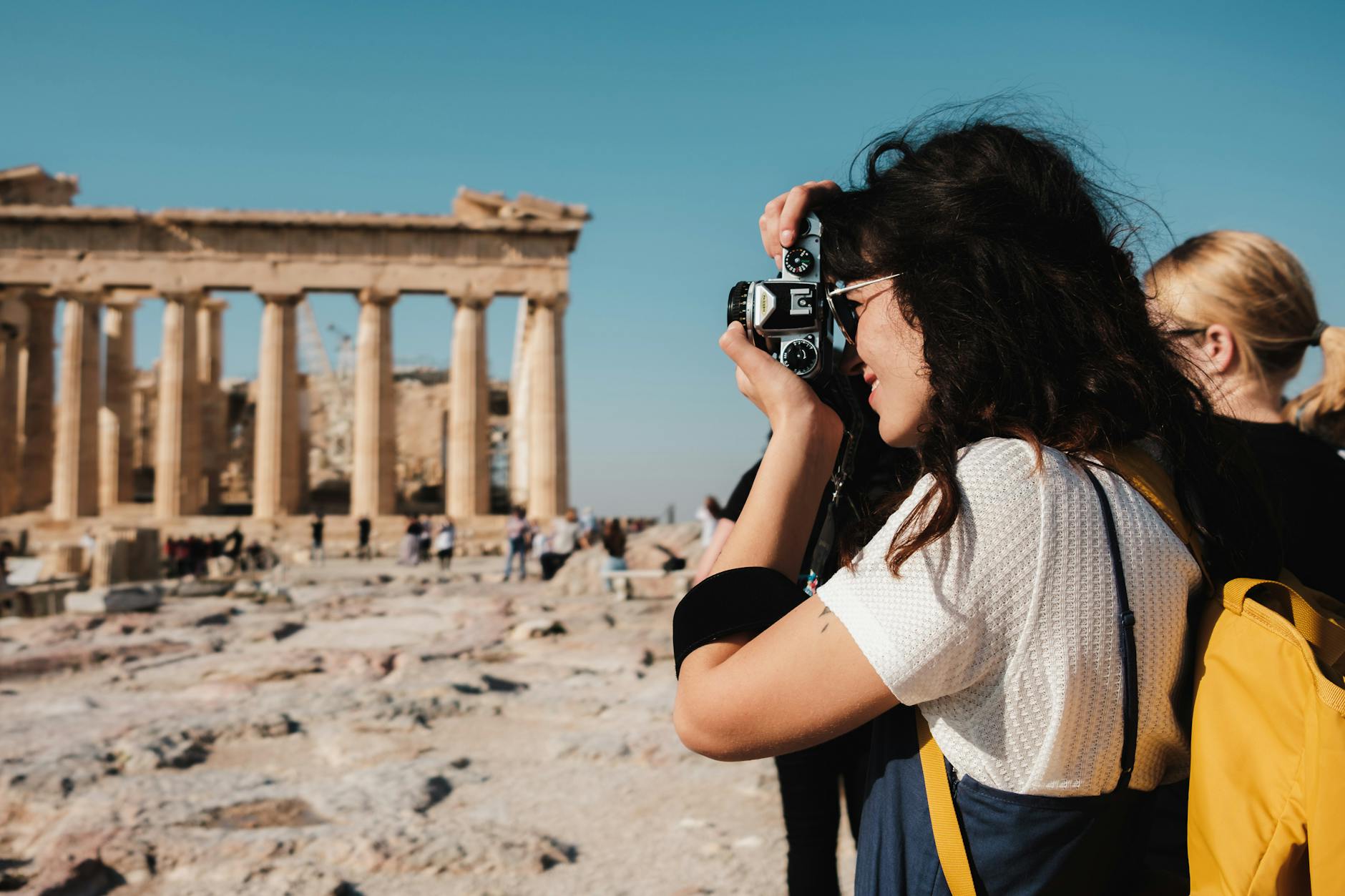 brunette woman taking pictures near parthenon