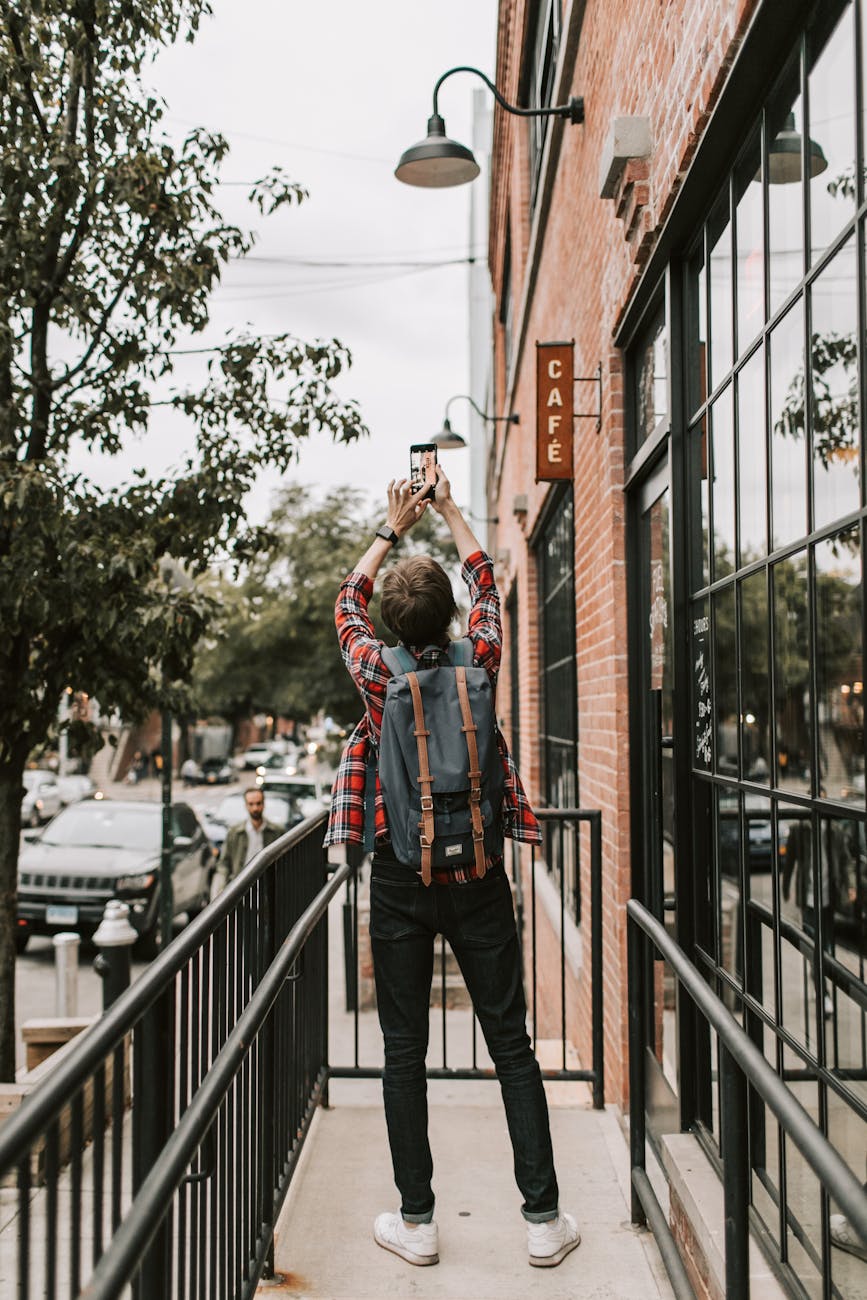 backpacker taking photo of sky in city
