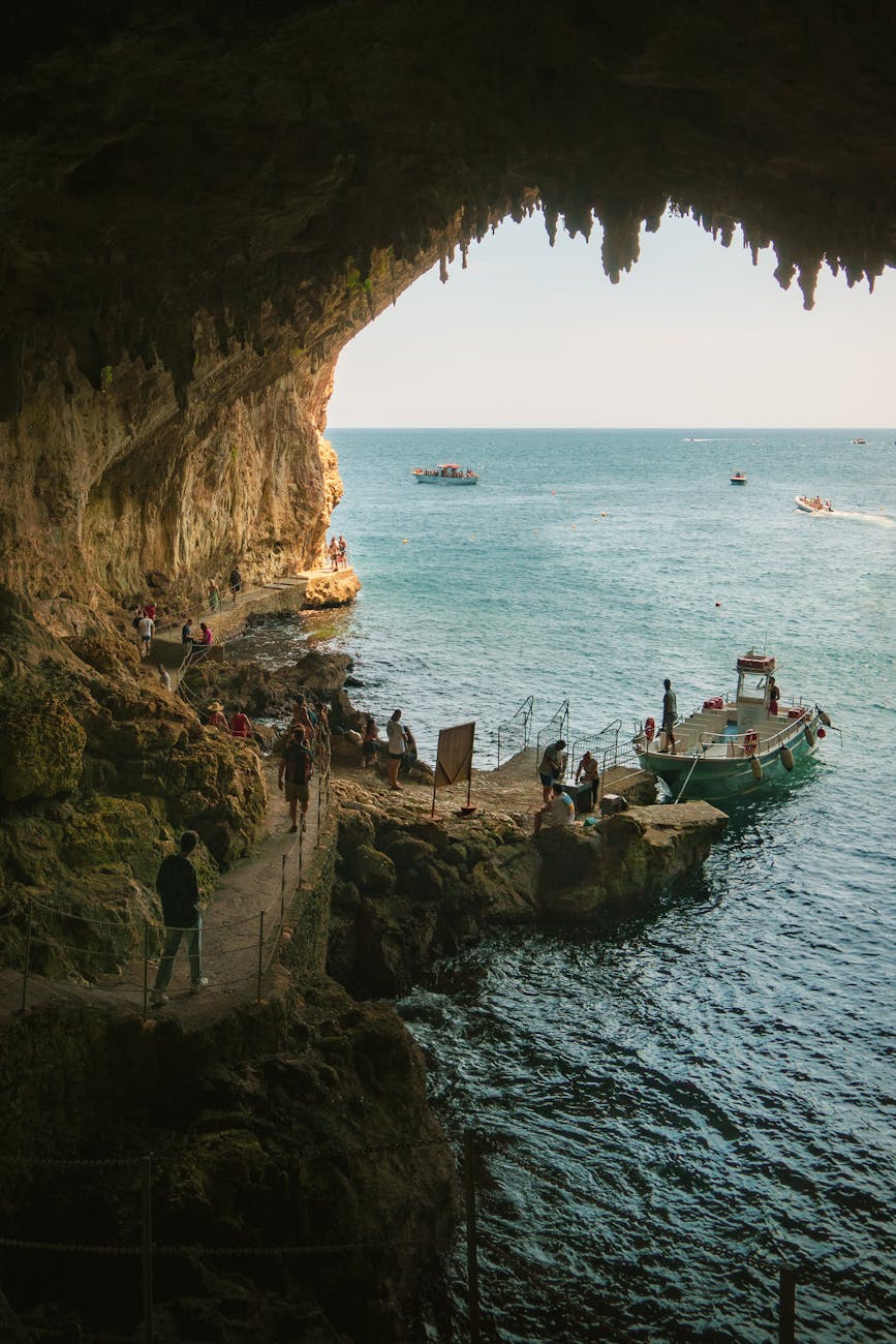 people on footpath in grotto on sea shore