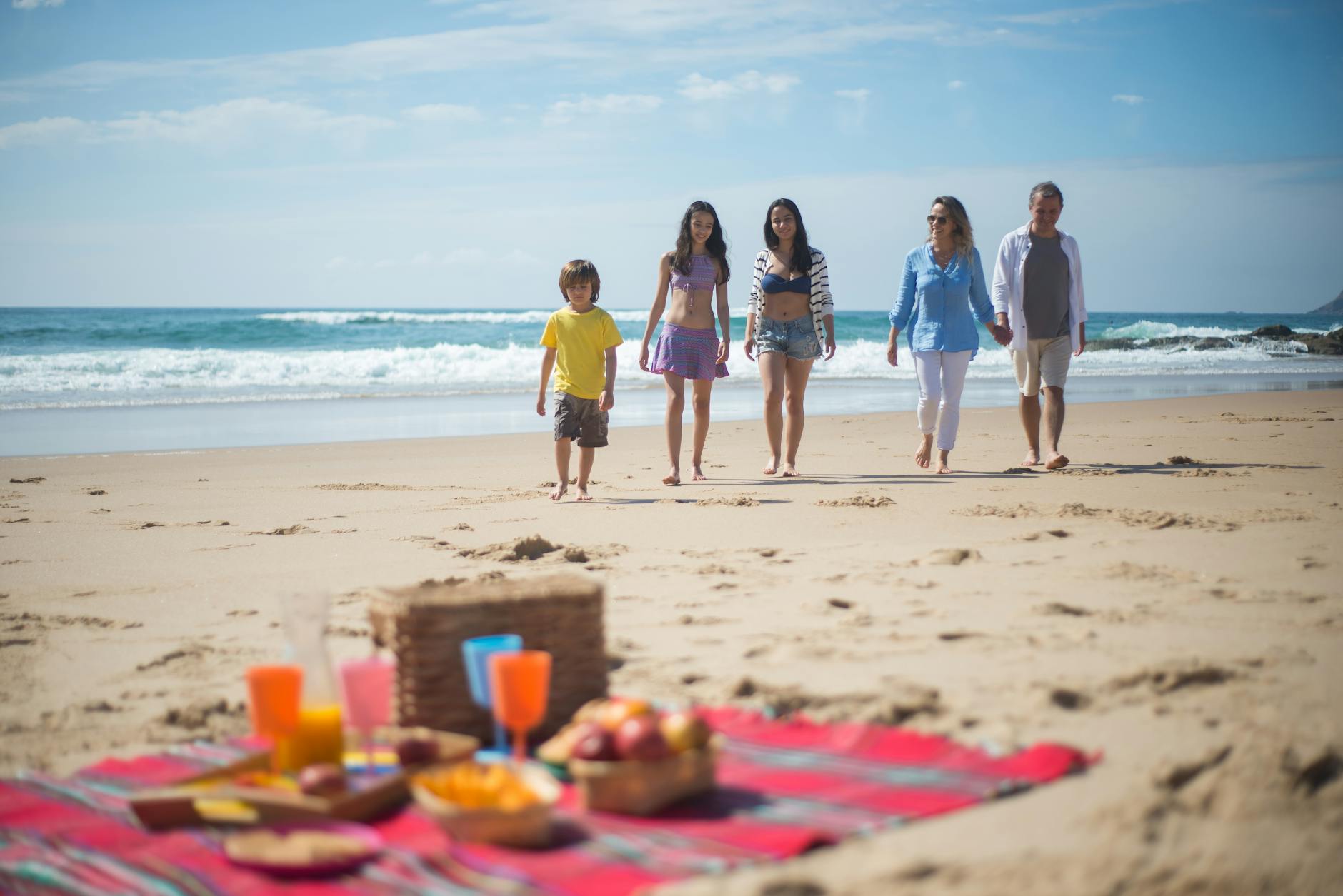 family walking towards the picnic blanket