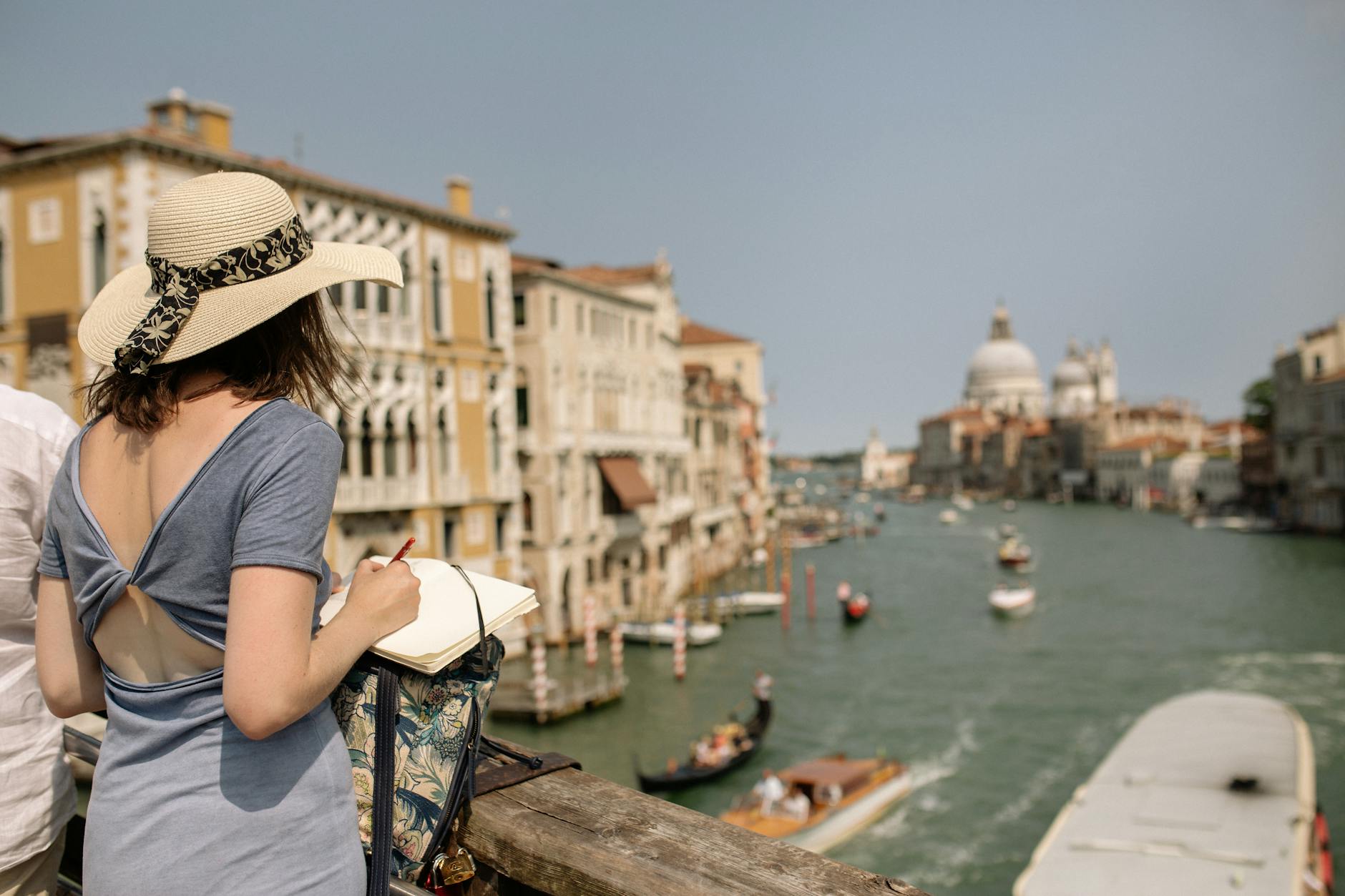 woman sketching canal from bridge in venice italy