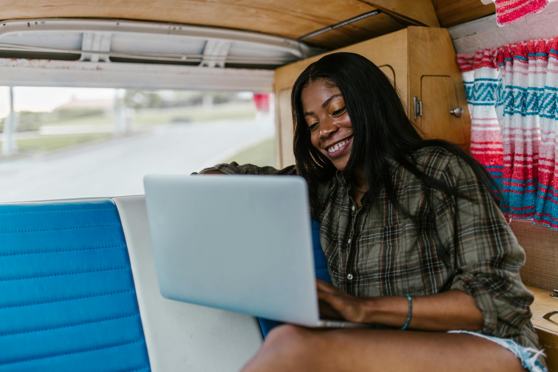 woman in checkered long sleeves using a laptop