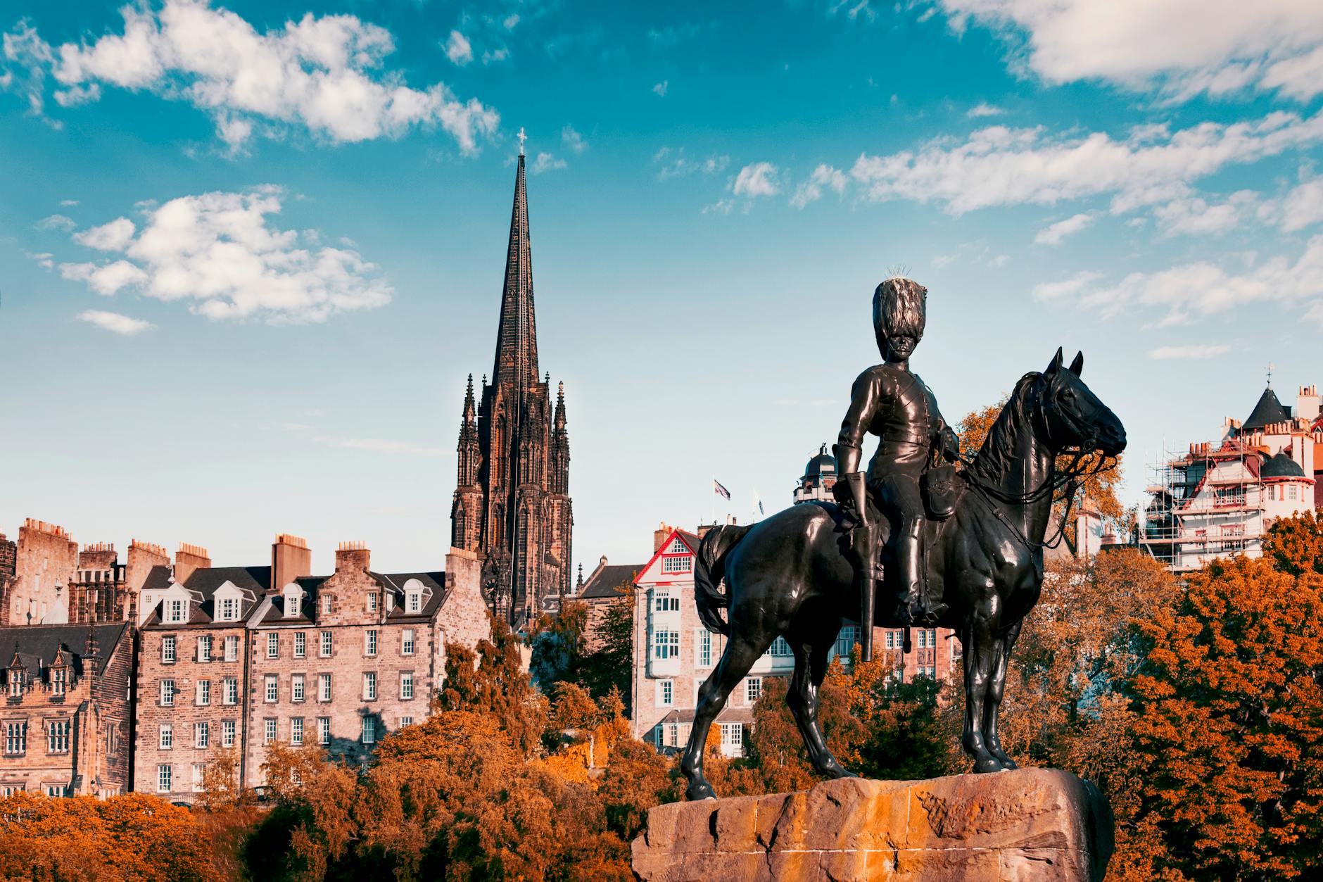 black statue of man riding horse near brown concrete building