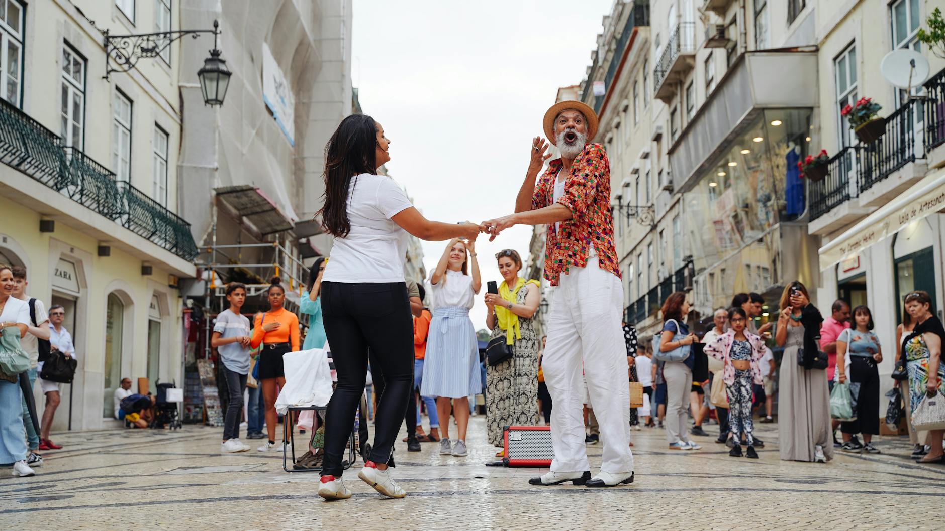 man and woman dancing in performance in alley in town